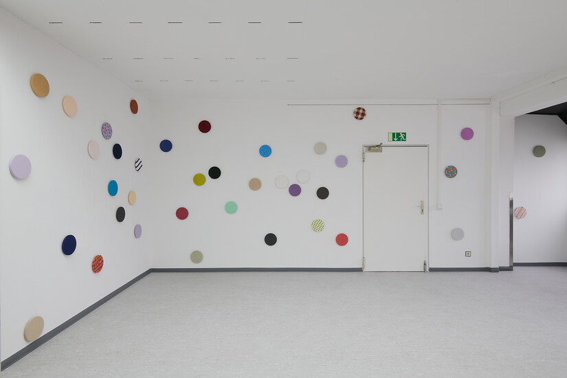 Konfetti (60-teilig), 2020 &ndash; Durchmesser á 20 cm; Hängung variabel; Stoffe von ausrangierten Kleidungsstücken, Holzscheiben; Foto: Ausstellungsansicht Annette Kradisch